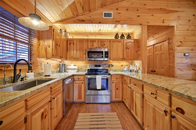 kitchen with sink, stainless steel appliances, decorative light fixtures, wooden walls, and wood ceiling