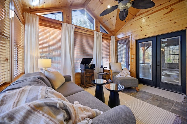 living room featuring french doors, ceiling fan, high vaulted ceiling, wooden ceiling, and wood walls