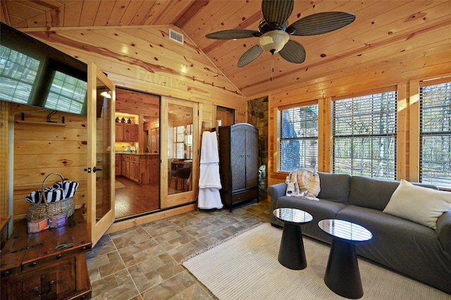 living room featuring wood walls, ceiling fan, wood ceiling, and lofted ceiling