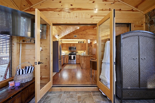 foyer with wood ceiling, wooden walls, and vaulted ceiling