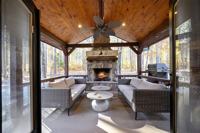 sunroom with lofted ceiling, ceiling fan, an outdoor stone fireplace, and wooden ceiling