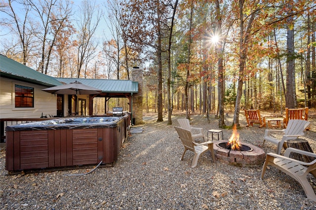 view of patio featuring a hot tub and a fire pit