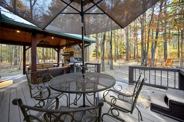 deck featuring grilling area and an outdoor stone fireplace