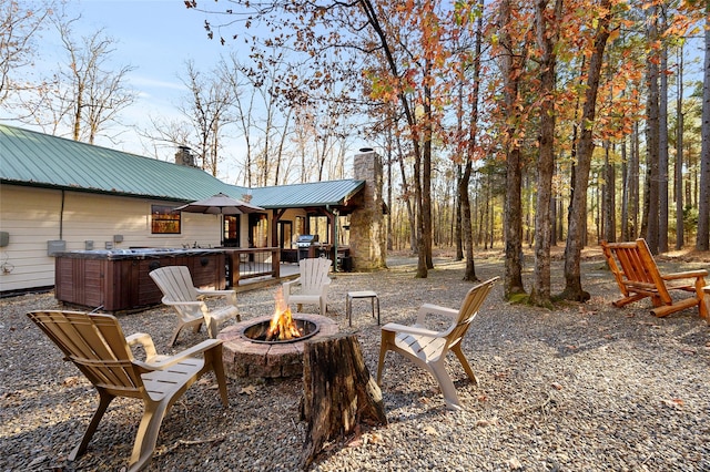 view of patio / terrace with area for grilling, a hot tub, and a fire pit