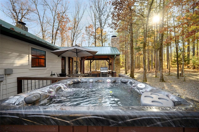 wooden deck with area for grilling and a hot tub