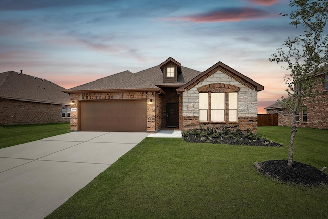 french provincial home featuring roof with shingles, an attached garage, concrete driveway, a front lawn, and stone siding