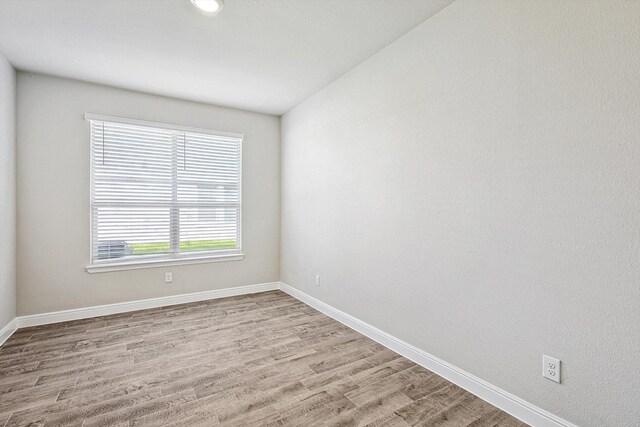 empty room featuring french doors and light hardwood / wood-style flooring