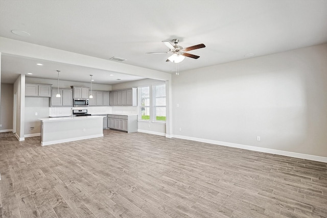 unfurnished living room featuring light hardwood / wood-style flooring and ceiling fan