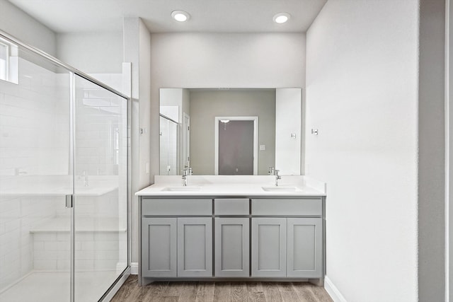 bathroom with vanity, wood-type flooring, and a shower with door