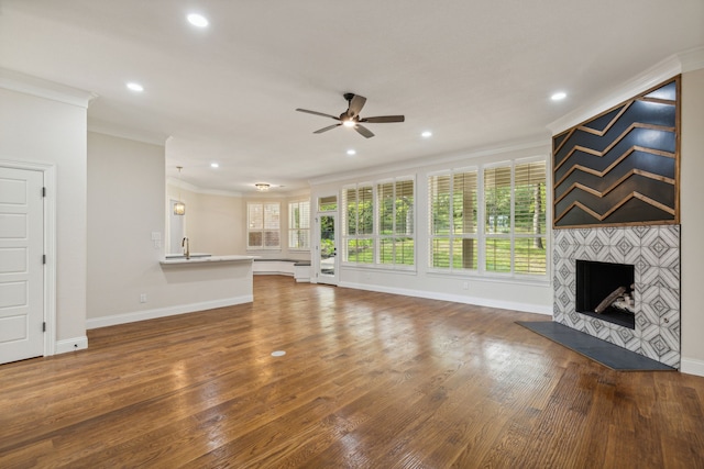 unfurnished living room with crown molding, wood-type flooring, and a fireplace