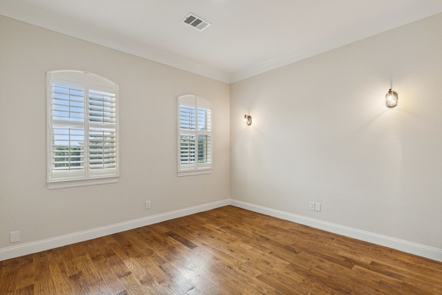 spare room featuring hardwood / wood-style floors and crown molding