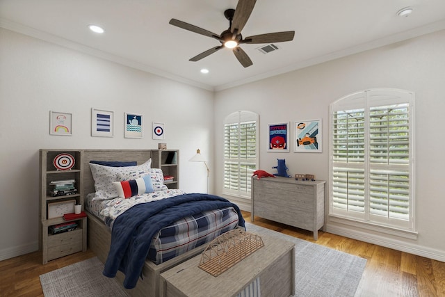 bedroom featuring hardwood / wood-style floors, ceiling fan, and ornamental molding