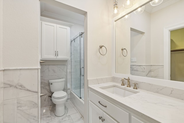 full bathroom with vanity, shower / bath combination with glass door, crown molding, toilet, and tile walls