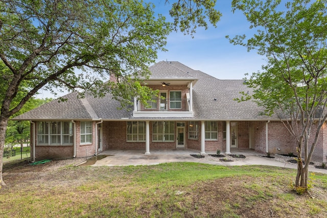 rear view of property featuring a yard, a balcony, ceiling fan, and a patio area