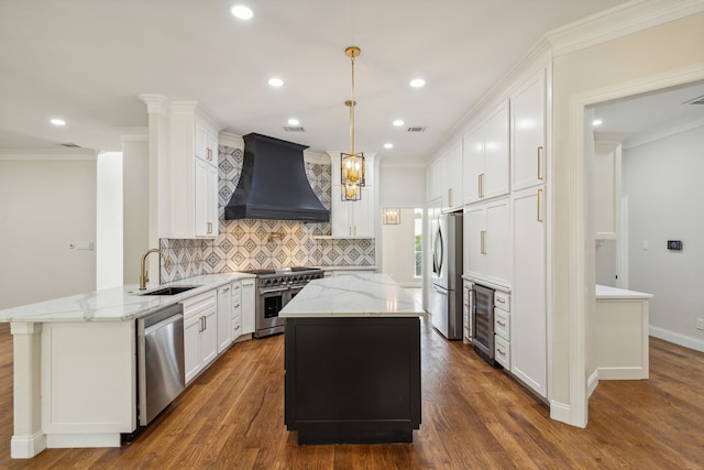 kitchen featuring pendant lighting, premium range hood, kitchen peninsula, white cabinetry, and stainless steel appliances