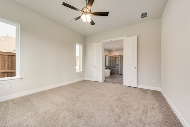 unfurnished bedroom with ensuite bathroom, light colored carpet, and ceiling fan