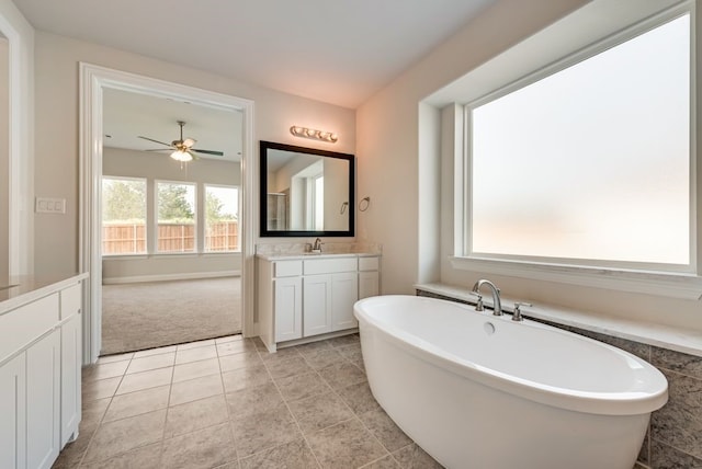 full bathroom featuring tile patterned flooring, ceiling fan, a freestanding bath, and vanity