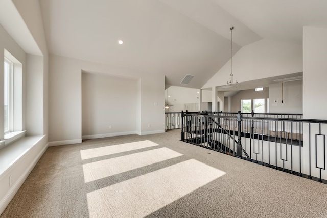 carpeted spare room with vaulted ceiling