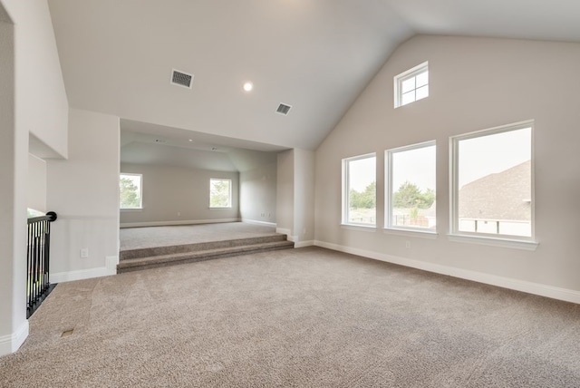 unfurnished living room featuring carpet floors, plenty of natural light, and high vaulted ceiling