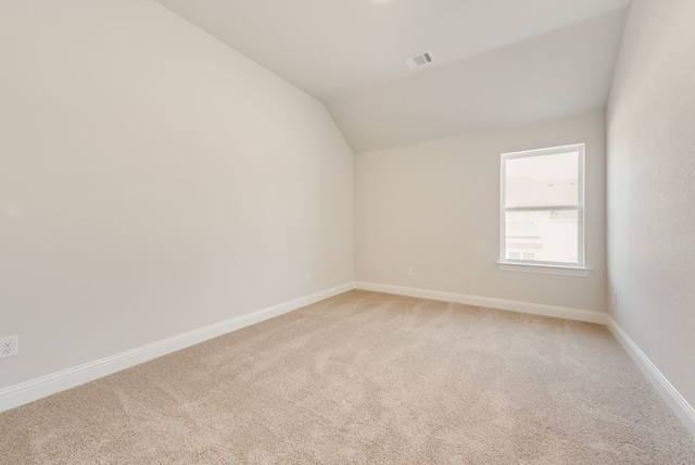 unfurnished room with carpet floors and vaulted ceiling