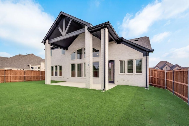 rear view of house featuring a yard and a patio