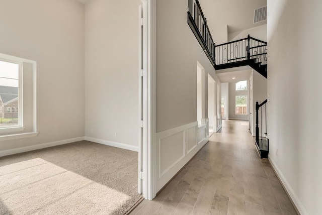 interior space featuring light hardwood / wood-style flooring and a towering ceiling