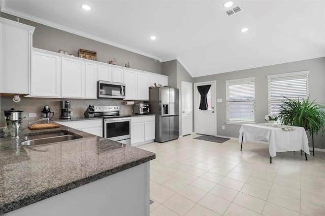 kitchen featuring white cabinetry, sink, vaulted ceiling, and stainless steel appliances