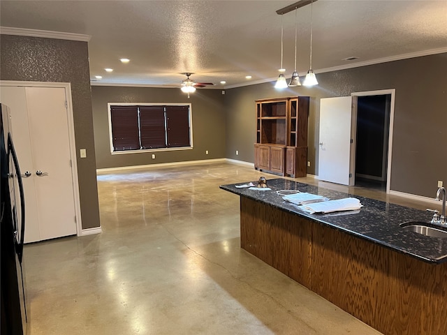 kitchen featuring hanging light fixtures, ceiling fan, a textured ceiling, refrigerator, and sink