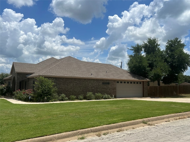 view of side of home featuring a garage and a lawn