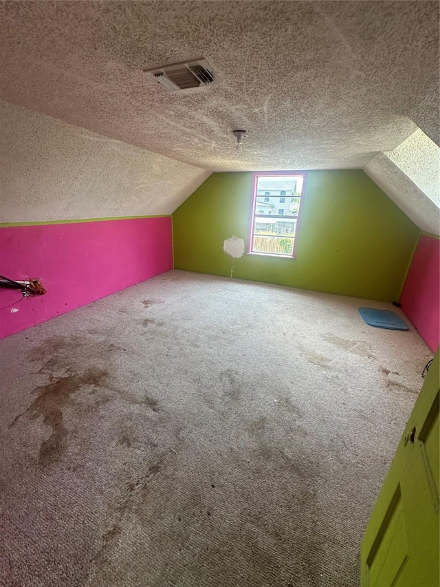 bonus room featuring a textured ceiling, carpet floors, and vaulted ceiling