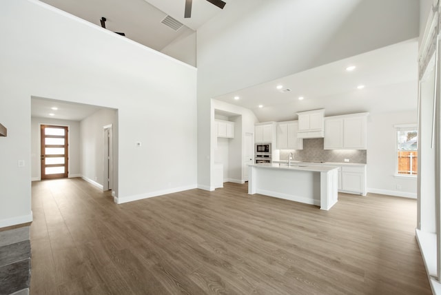 interior space featuring light wood-type flooring, a wealth of natural light, high vaulted ceiling, and sink