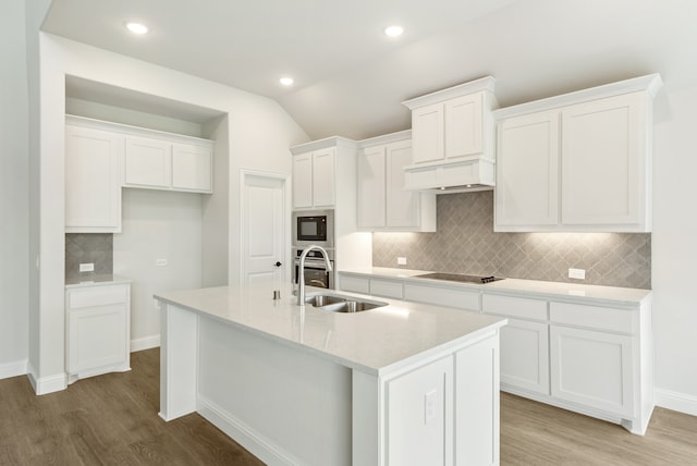 kitchen featuring hardwood / wood-style flooring, white cabinets, sink, and backsplash