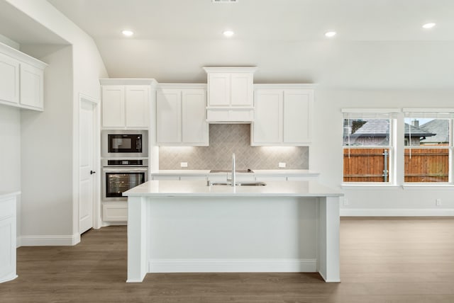 kitchen featuring sink, hardwood / wood-style flooring, black microwave, white cabinetry, and oven