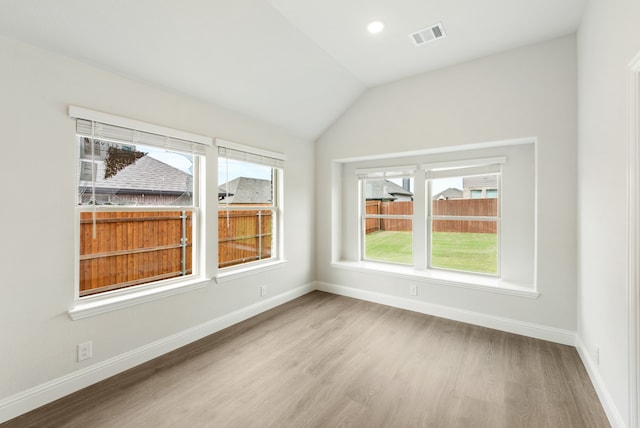 unfurnished room featuring vaulted ceiling and wood-type flooring