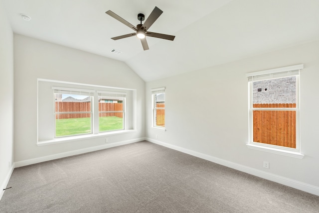 carpeted spare room with ceiling fan and vaulted ceiling