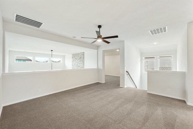 unfurnished room featuring ceiling fan, carpet, and a healthy amount of sunlight