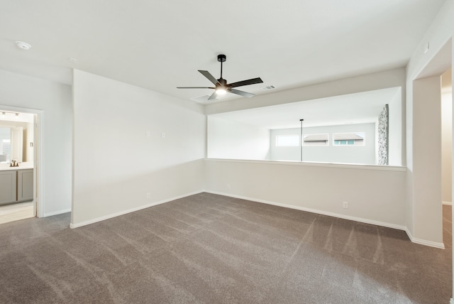 carpeted spare room featuring ceiling fan, plenty of natural light, and sink