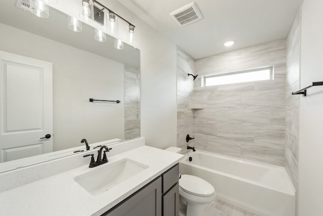 full bathroom featuring tiled shower / bath, vanity, and toilet