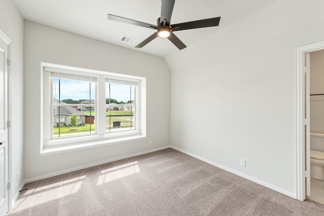 spare room with ceiling fan, light carpet, and lofted ceiling