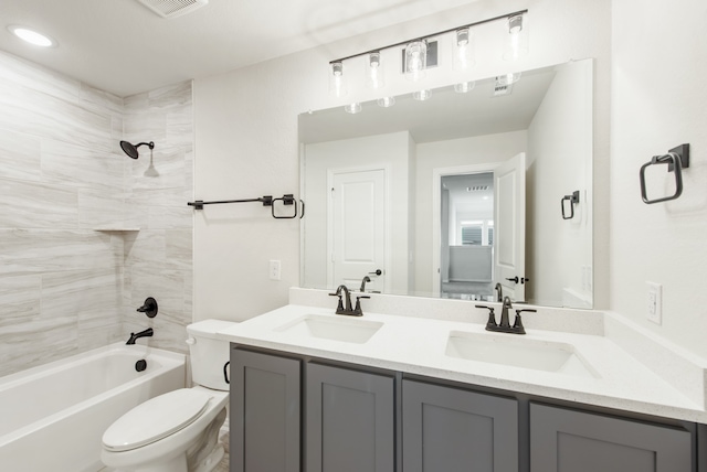 full bathroom with toilet, tiled shower / bath, and dual bowl vanity