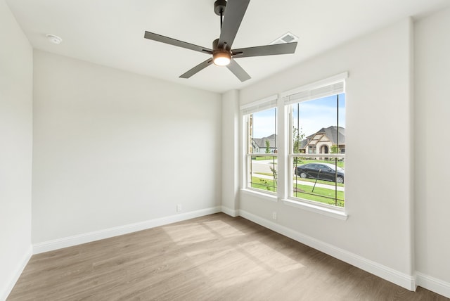 empty room with ceiling fan, plenty of natural light, and light hardwood / wood-style floors