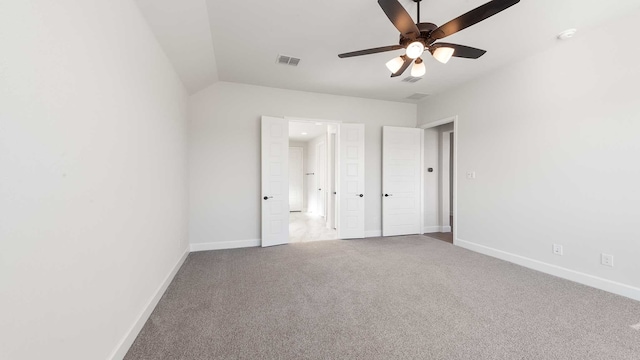 unfurnished bedroom featuring ceiling fan, carpet flooring, and lofted ceiling