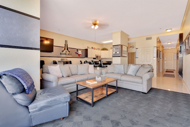 living room featuring ceiling fan, dark colored carpet, and crown molding