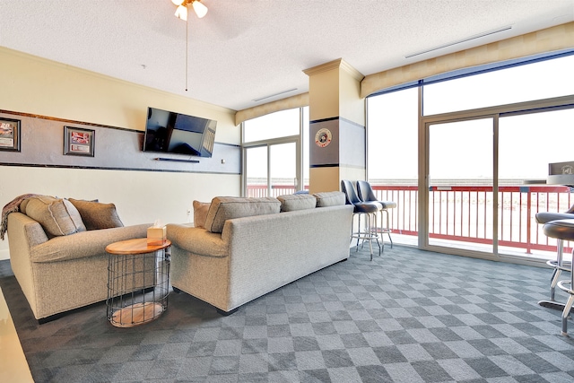 carpeted living room with ceiling fan and a textured ceiling