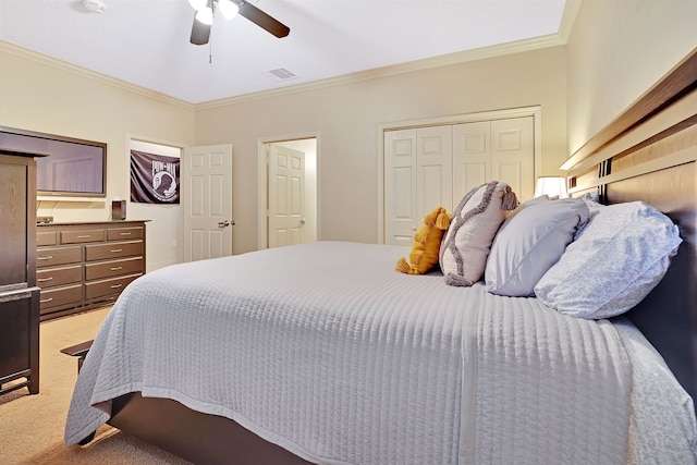 carpeted bedroom with ceiling fan, a closet, and crown molding