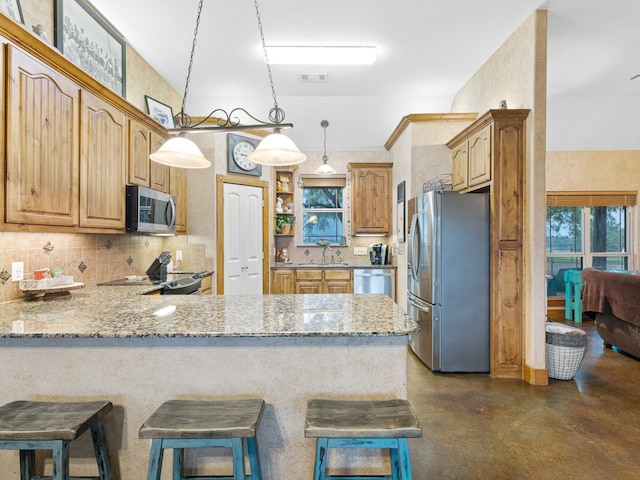 kitchen with stainless steel appliances, kitchen peninsula, hanging light fixtures, and a kitchen breakfast bar