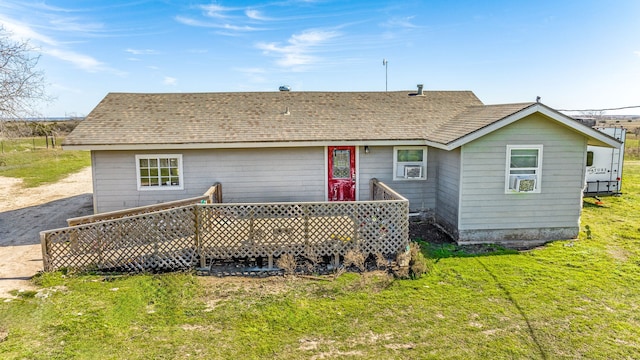 back of property with a wooden deck and a lawn