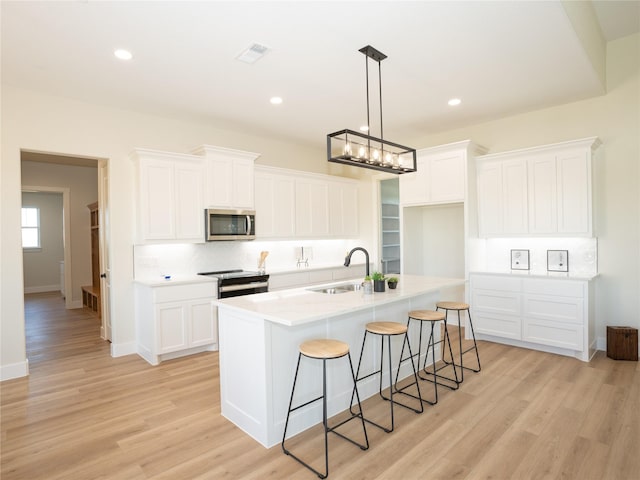 443 Schneider Rd, Sherman, TX 75090 - kitchen with stainless steel appliances, a sink, decorative backsplash, a center island with sink, and white cabinetry