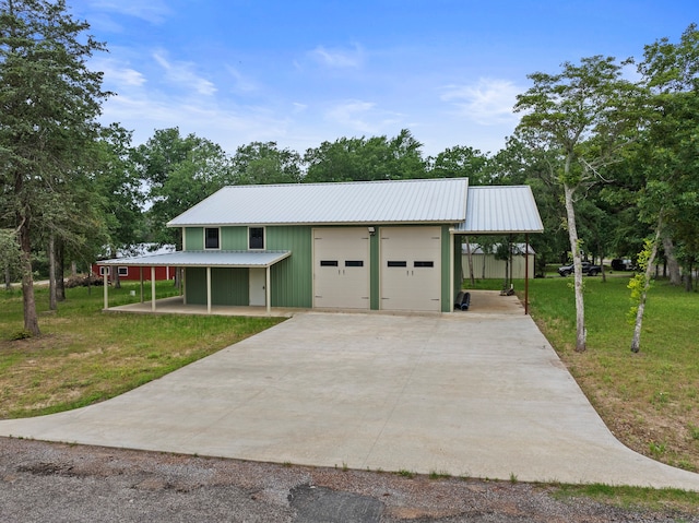 view of front facade with a front lawn, an outdoor structure, a carport, and a garage