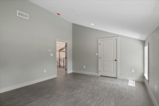 empty room featuring vaulted ceiling and dark hardwood / wood-style floors